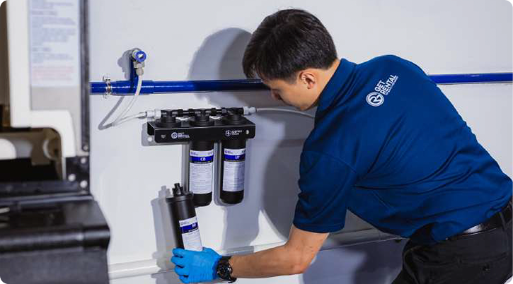 Technician installing commercial water filtration