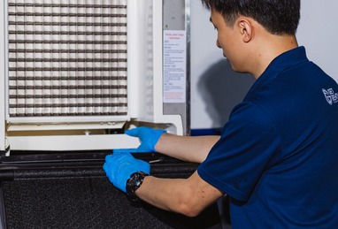 Technician inspecting refrigeration unit coils